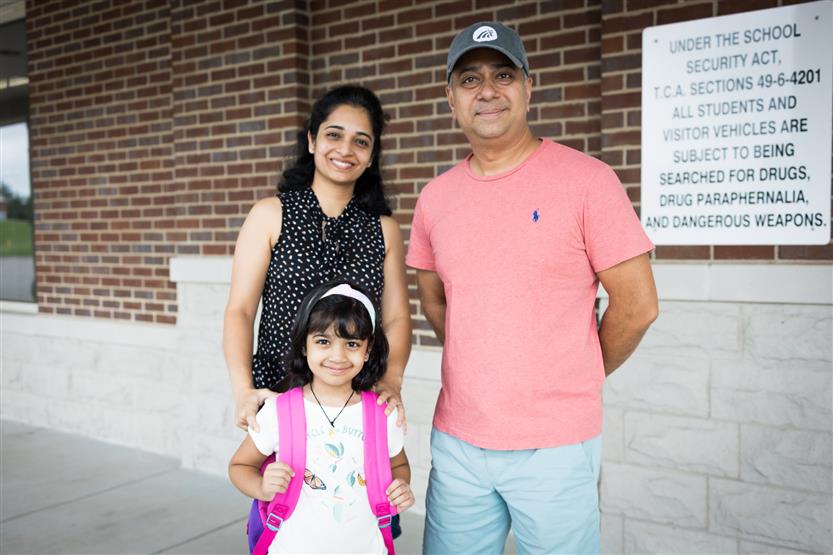 A mother, father and daughter smile